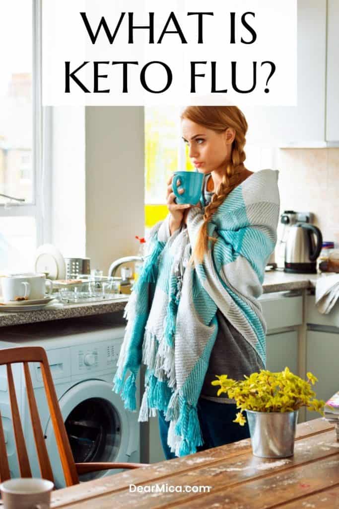 Woman with blanket wrapped around her shoulders drinking tea, what is the keto flu.
