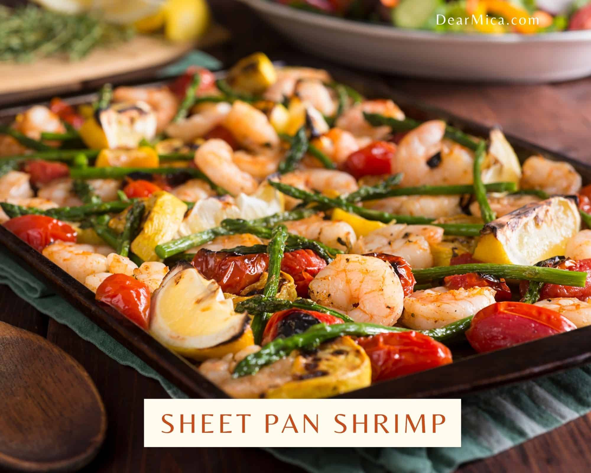 side view of sheet pan shrimp with asparagus, lemon, tomatoes and yellow squash