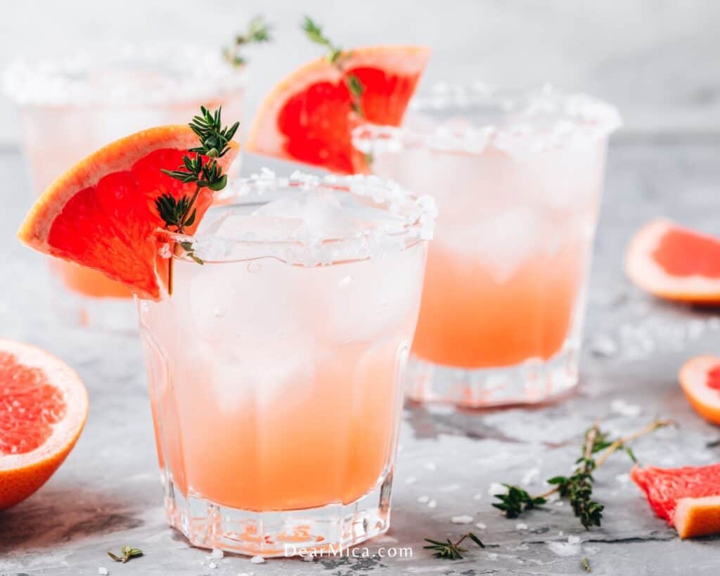 two glasses of low carb salty dog cocktail with ice garnished with Grapefruit slice.
