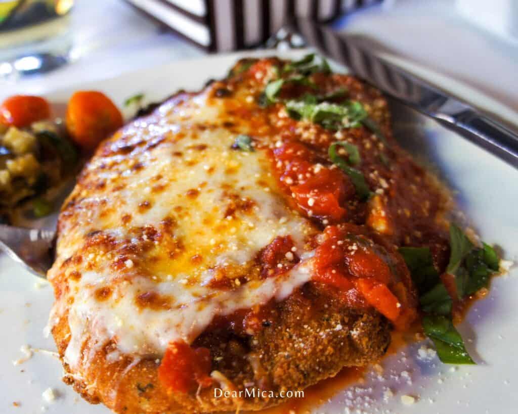 chicken parmigiana served on a white plate.
