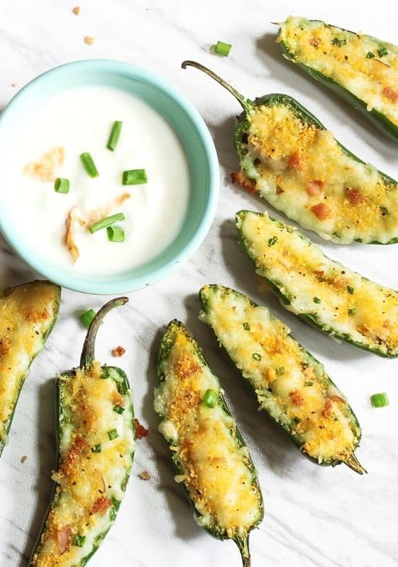 Top view of low carb and keto-friendly Grilled Jalapeno Poppers with dipping sauce on white background.