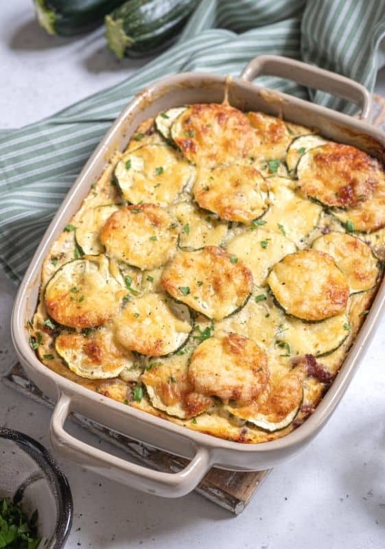 Angled side view of a Low Carb Zucchini Casserole on a baking dish on a gray background.