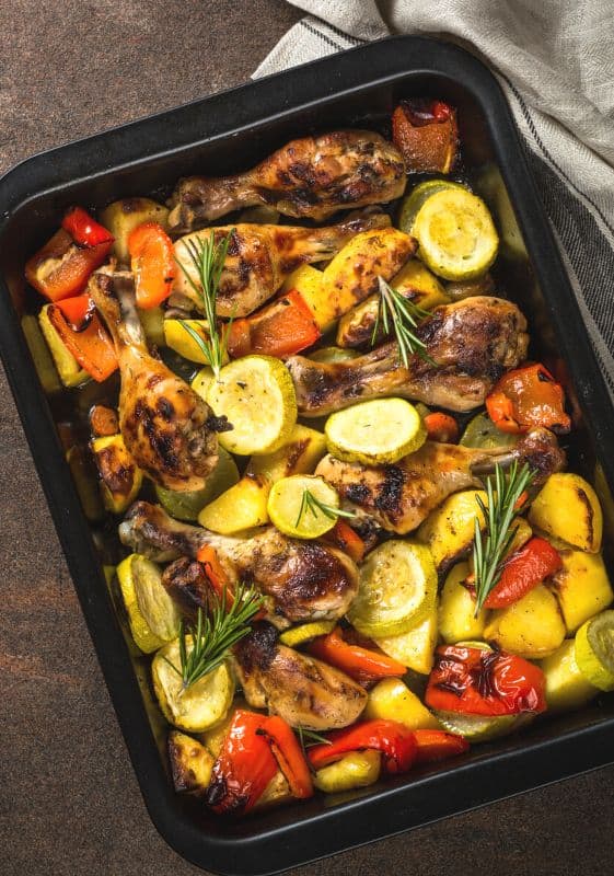 Baked Butter Garlic Chicken and Zucchini on a baking sheet garnished with fresh rosemary.