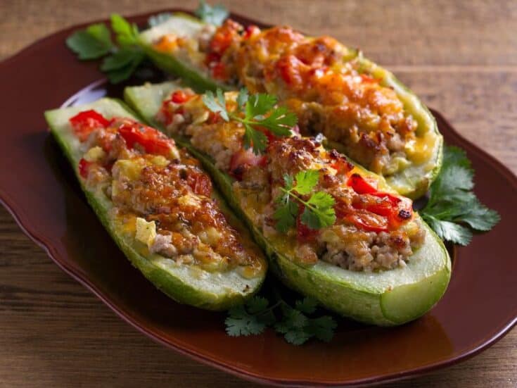 Three Ground Beef Zucchini Boats served on a brown platter.