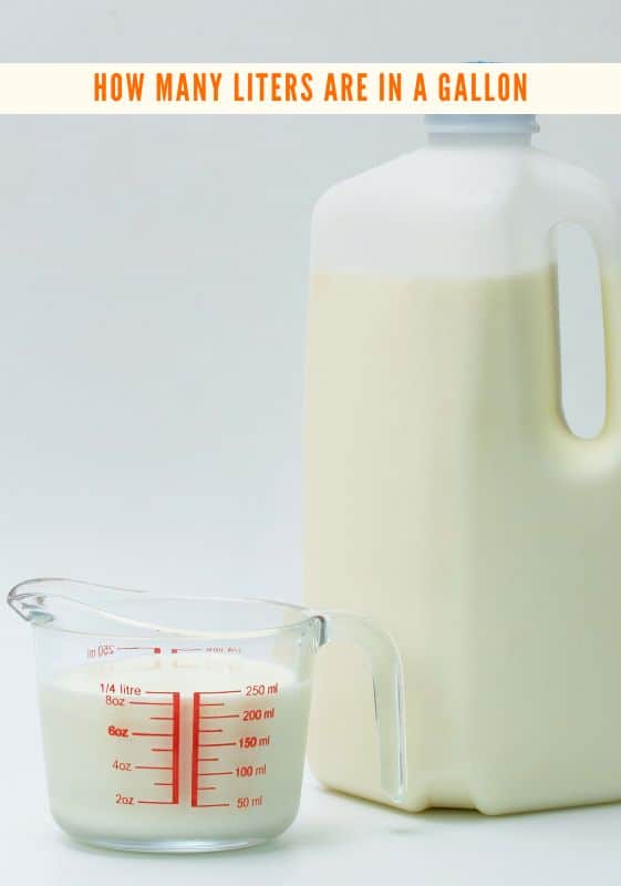 A pyrex glass measuring cup filled with milk and a half a gallon of milk next to it.
